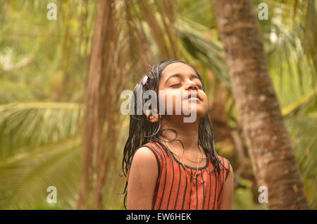 Bella kid godendo la pioggia a occhi chiusi Foto Stock