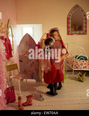 Due piccole bambine vestirsi in una economia degli anni Novanta camere da letto di stile per solo uso editoriale Foto Stock