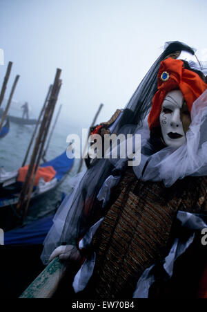 Un Reveller indossando maschera tradizionale e accappatoi presso il Carnevale di Venezia per solo uso editoriale Foto Stock