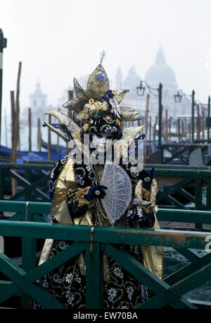 Un Reveller indossando maschera tradizionale e accappatoi presso il Carnevale di Venezia per solo uso editoriale Foto Stock