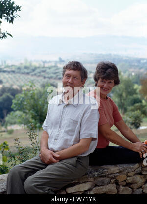 Ritratto di un sorridente giovane seduto su un muro di pietra per solo uso editoriale Foto Stock