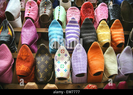 Fake,merci contraffatte.Colorata pantofole scarpe// stile locale babouches in pelle è realizzato a mano da artigiani marocchini in vendita bancarella di strada, souk,Marrakech Foto Stock