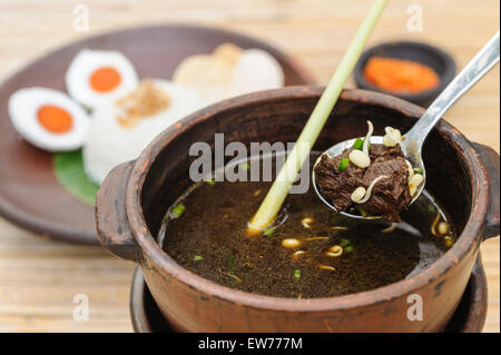 Indonesiano zuppa di carne di manzo servita con beccucci di fagioli, riso, uova e sambal. Foto Stock