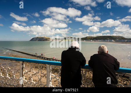 Nel Regno Unito, in Galles, Conwy, Llandudno North Beach, pier, due uomini appoggiata sulla ringhiera guardando verso Little Orme Foto Stock