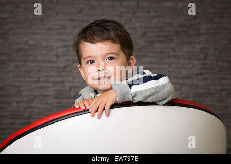 Piccolo Ragazzo seduto in poltrona Foto Stock