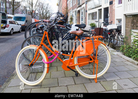 Le donne di colore arancione di biciclette parcheggiate nel centro di amsterdam Foto Stock