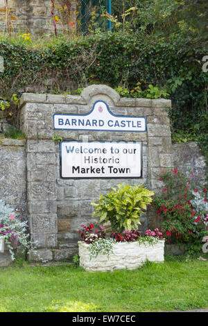 Segno di benvenuto insieme all'ombra delle rovine del castello a Barnard Castle, nella contea di Durham, adiacente al Barnard Castle bridge. Foto Stock