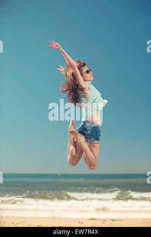 Donna salta sulla spiaggia, Marbella, Spagna Foto Stock