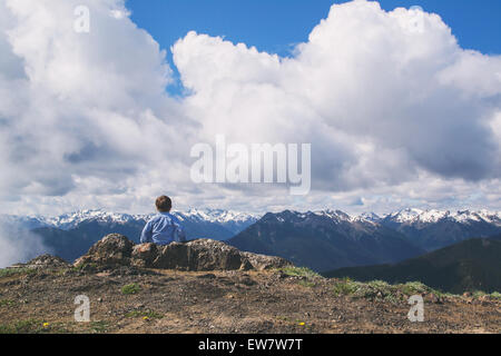 Vista posteriore di un ragazzo seduto in montagna guardando vista, Stati Uniti Foto Stock