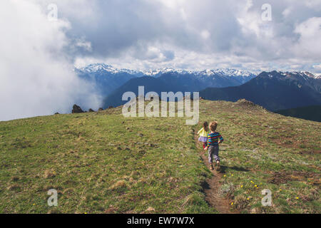 Due bambini che corre lungo un percorso su una montagna Foto Stock