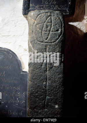 Cross-colonne scolpite nella chiesa Llanbadrig, Anglesey, forse un inizio di grave marker con una ruota-croce al di sopra di un lineare a croce latina. Pesce & palm simboli? Foto Stock