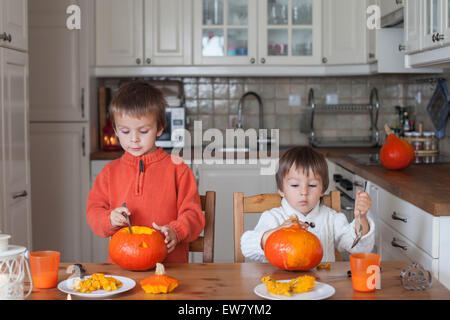 Due ragazzi adorabili, preparazione di jack o lanterna per Halloween a casa Foto Stock