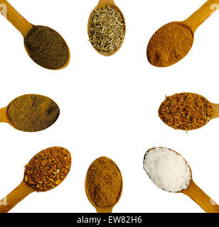 Cucchiai di legno con spezie con diverse spezie su uno sfondo bianco Foto Stock