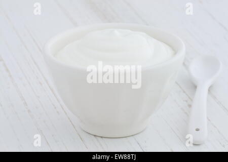 Deliziosi e nutrienti e sani e freschi plain yogurt greco antico sulla tavola di legno Foto Stock