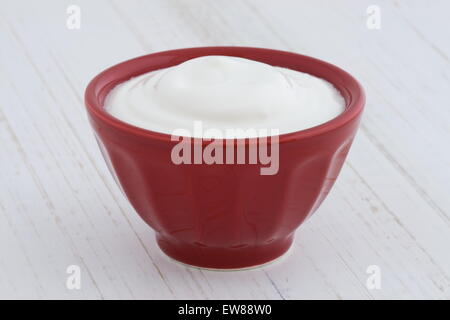 Deliziosi e nutrienti e sani e freschi plain yogurt greco antico sulla tavola di legno Foto Stock