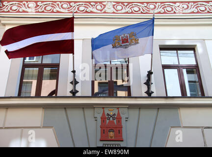 Bandiere e lo stemma su un edificio di appartamenti a Riga Foto Stock