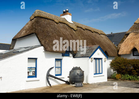 Irlanda, Co Wexford, Kilmore Quay, idilliaco cottage con il tetto di paglia nel centro del villaggio con giardino nautico decorazioni Foto Stock