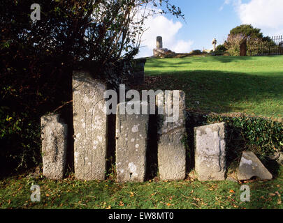 Inizio Medioevo cross-contrassegnato lapidi in Llangaffo sagrato, Anglesey: cross-albero & chiesa vecchia fondamenta su affioramento. Presto il sito monastico. Foto Stock