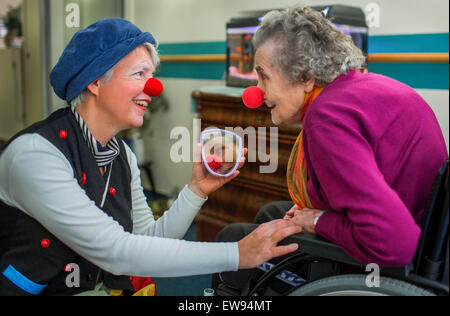 Schwerin, Germania. 05 Giugno, 2015. Ospedale clown "bene" (Ines Vowinkel, L) sorregge un piccolo specchio per Annemarie Leonhardt che ha messo su un rosso del clown naso durante un tour attraverso i reparti di assistenza infermieristica del 'Augustenstift' nursing home in Schwerin, Germania, 05 giugno 2015. I clown hanno visitato i pazienti dementi e le persone che richiedono una cura una volta al mese per gli ultimi due anni. Foto: Jens Buettner/dpa/Alamy Live News Foto Stock