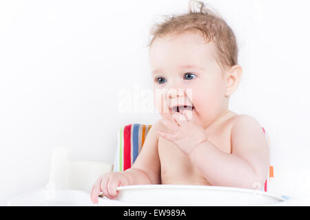 Carino il bambino seduto in una sedia alta in attesa per la cena Foto Stock