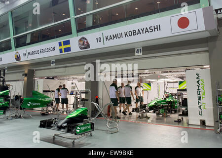 Il pit box Caterham 2014 al Gran Premio di Singapore offre uno sguardo sulla configurazione del team durante la gara. L'immagine cattura la precisione e l'organizzazione che sono fondamentali per le operazioni di pit in Formula 1. Foto Stock