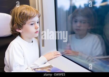 Poco stanco ragazzo in un treno ad alta velocità Foto Stock