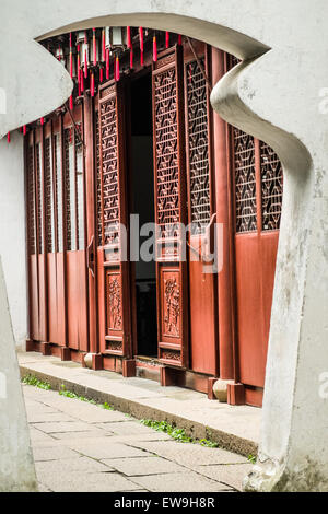 Ornate porte in legno in stile cinese tradizionale, viste attraverso un arco nel Giardino Yuyuan, Shanghai, Cina Foto Stock