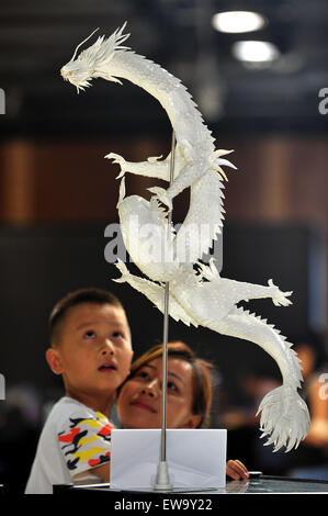 Wuhan, la Cina della provincia di Hubei. Xx Giugno, 2015. Un bambino guarda un drago di carta a Wuhan, capitale della Cina centrale della provincia di Hubei, 20 giugno 2015. La carta mostra d'arte qui visualizzato più di cento opere di origami. © Shi Wei/Xinhua/Alamy Live News Foto Stock