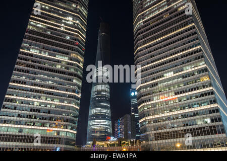 Torre di Shanghai illuminata tra 2 edifici grattacieli a Pudong, Shanghai, Cina Foto Stock