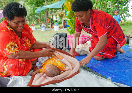 Madre prendersi cura del suo bambino durante la cerimonia del villaggio, Yasawa isola gruppo, Figi, South Pacific islands, pacifico, Foto Stock