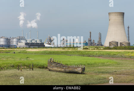 Troon Haven con la bassa marea e il grande impianto chimico in background con un marciume imbarcazione in legno spiaggiata sulla banca di fango. Foto Stock