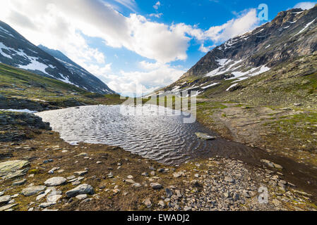 Acque che scorre dalla fusione di alimentazione neve alpina ad alta quota in lago idilliaco ambiente incontaminato una volta coperta da ghiacciaio Foto Stock