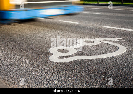 Auto elettrica segno sulla strada con i mezzi di trasporto pubblico viene eseguito in background. Foto Stock