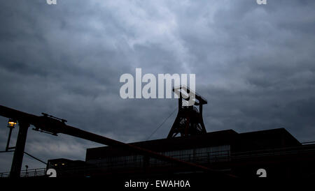 Nuvole scure contro la silhouette della Zeche Zollverein, Essen, Germania 20 giugno 2015. Il 'ExtraSchicht - La Notte di cultura industriale' è il suo quindicesimo anno offre un tour di notte nel suo programma. I partecipanti di 20 città e 45 luoghi con circa 2.000 artisti partecipano. Old industrial reliquie del passato sono portati alla vita con fuochi d'artificio, musica, danza e teatro. Foto: Marcel Kush/dpa Foto Stock