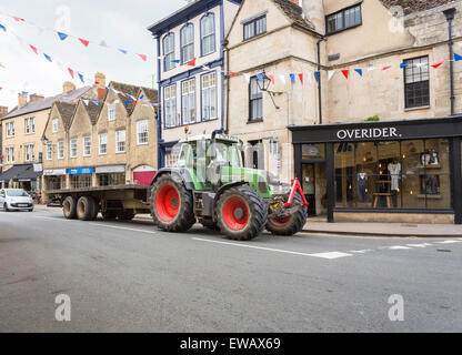 Trattore con ruote enormi nella strada principale di Tetbury, una piccola città nel distretto di Cotswold del Gloucestershire, Regno Unito Foto Stock