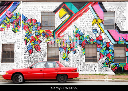 Buick Skylark parcheggiata di fronte i graffiti sulla parete ovest Cary street a Richmond, Virgina. Murale dipinto oltre le parole di gentilezza Foto Stock
