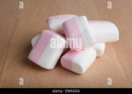 Marshmallows bianco e rosa su una superficie in legno Foto Stock