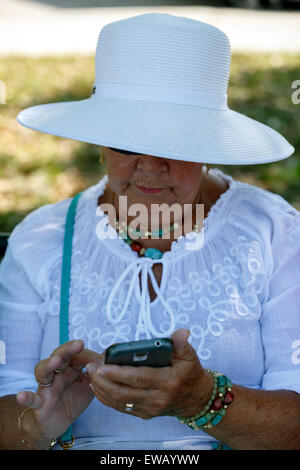 Senior texting femmina sul suo telefono cellulare silver surfer Foto Stock