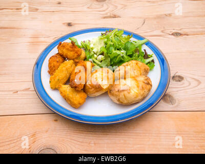 Crocchette di merluzzo bianco classico brasiliano portoghese o piatto è servito con insalata e patate. Spesso servito come snack da bar. Foto Stock