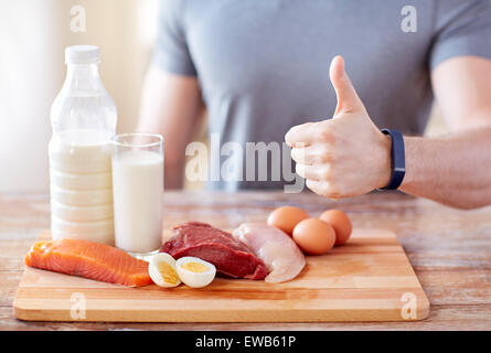 Uomo con alimenti ricchi di proteine che mostra pollice in alto Foto Stock