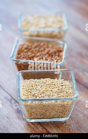 Chiusura del grano in ciotole in vetro su un tavolo di legno Foto Stock