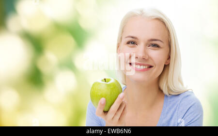 Donna felice di mangiare mela verde Foto Stock