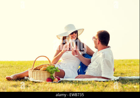 Coppia sorridente bevendo champagne sul picnic Foto Stock