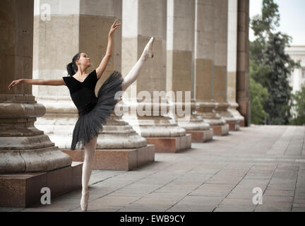 Ragazza ballerina flats permanente sulla tiptoes sulla strada Foto Stock