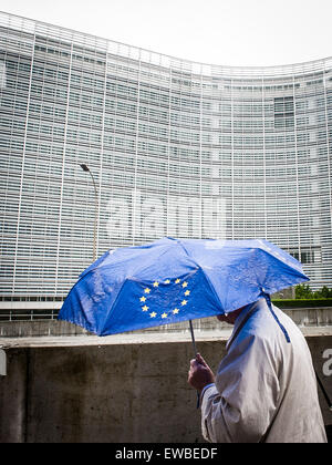 Bruxelles, BXL, Belgio. Il 22 giugno, 2015. Pedone sotto ombrellone con la bandiera dell'Unione europea sta camminando lungo la Commissione europea ha sede a Bruxelles in Belgio su 22.06.2015 Capi di stato della zona euro sarà geather per vertice di emergenza sul debito greco oggi in sede UE da Wiktor Dabkowski © Wiktor Dabkowski/ZUMA filo/Alamy Live News Foto Stock