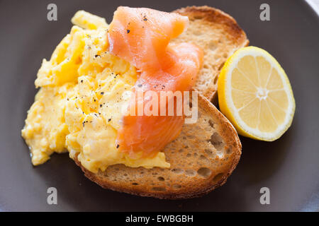 Salmone affumicato e uova strapazzate su pane tostato Foto Stock