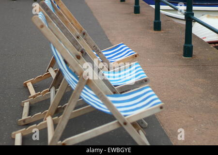 Tre lonely, vuoto sedie a sdraio in attesa di essere seduto su e utilizzato. Guardando verso il mare. Foto Stock