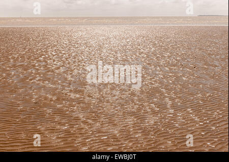 Avvicinando la bassa marea a Dovercourt Bay con sabbia esposto banche e increspata patterns in contrasto con orizzonte fino al mare Foto Stock