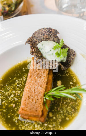 Salate toast alla francese 3.0, riempito con parmigiano Royal, tapenade a molla, un cetriolo mouse e un nero di quinoa croccante, con spinaci e ortica brodo, servita à la Nage, sul tram Hoftrammm ristorante, Den Haag, Paesi Bassi. Foto Stock