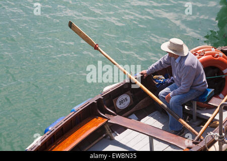 Ferry man godendo il sole sulla barca a remi durante l'attesa dei passeggeri a Weymouth Dorset, in giugno Foto Stock